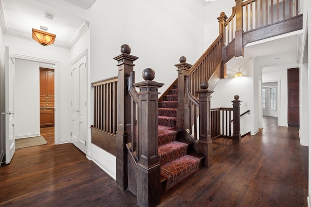 staircase with hardwood / wood-style floors and ornamental molding