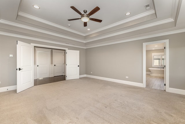 unfurnished bedroom with connected bathroom, a raised ceiling, ceiling fan, and crown molding