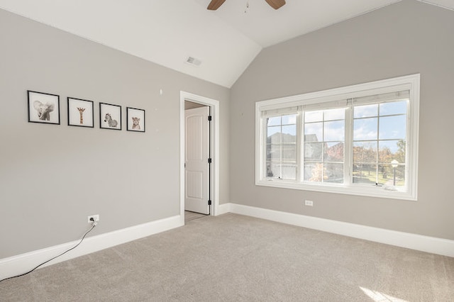 unfurnished bedroom featuring ceiling fan, vaulted ceiling, and light colored carpet