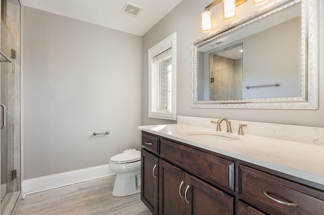 bathroom featuring a shower with door, vanity, toilet, and wood-type flooring