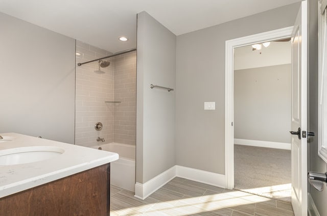 bathroom with tiled shower / bath combo and vanity