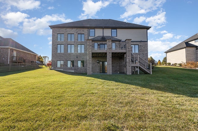 rear view of property featuring a deck and a lawn