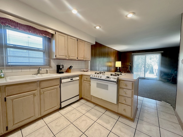 kitchen featuring light colored carpet, sink, backsplash, light brown cabinetry, and white appliances