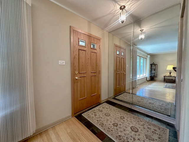 foyer entrance with hardwood / wood-style floors and crown molding