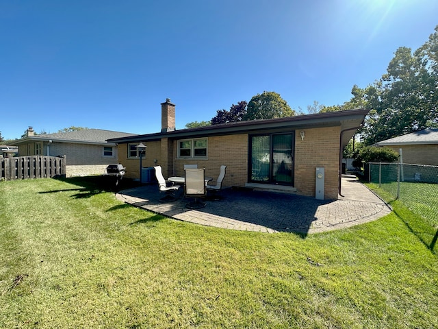 back of property with a patio and a yard