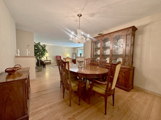 dining area featuring a notable chandelier and light hardwood / wood-style floors