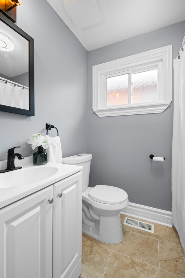 bathroom with tile patterned flooring, vanity, and toilet