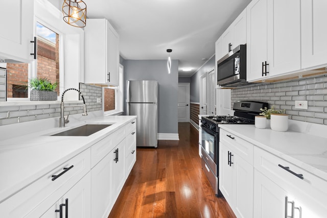 kitchen featuring pendant lighting, white cabinets, sink, and stainless steel appliances