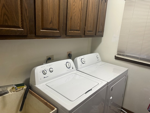 laundry room featuring washing machine and clothes dryer and cabinets