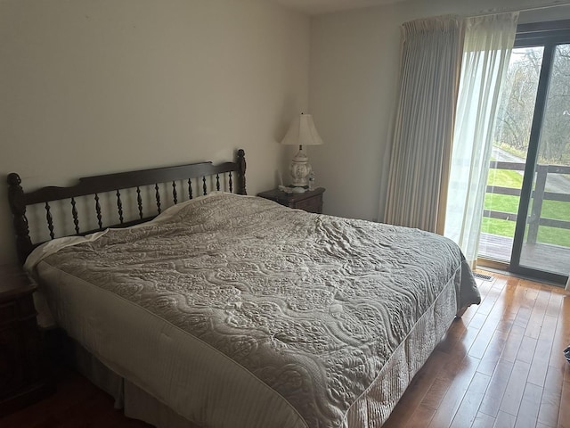 bedroom with access to outside and wood finished floors