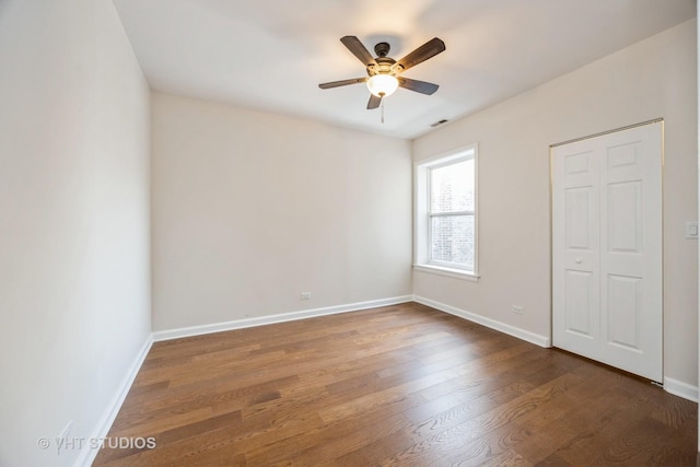 unfurnished bedroom with dark wood-type flooring, baseboards, and a ceiling fan