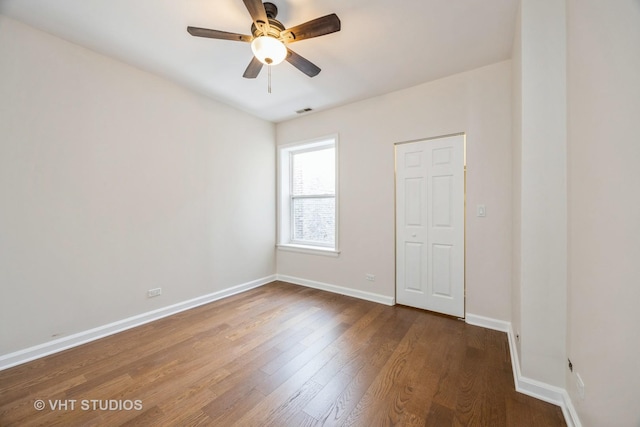 unfurnished bedroom featuring visible vents, dark wood finished floors, baseboards, and ceiling fan