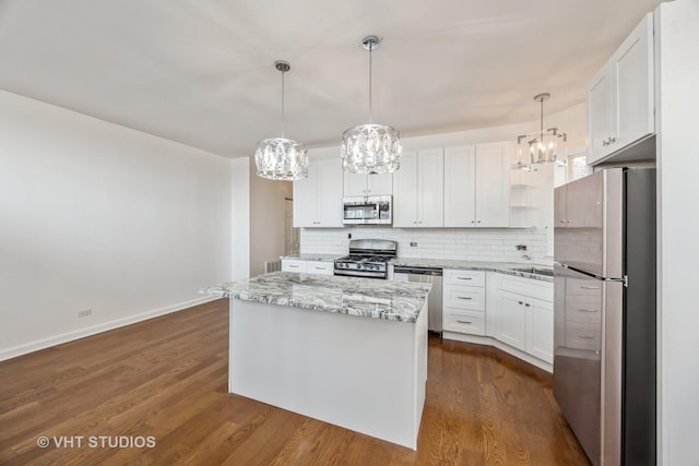 kitchen featuring appliances with stainless steel finishes, a center island, pendant lighting, and white cabinets