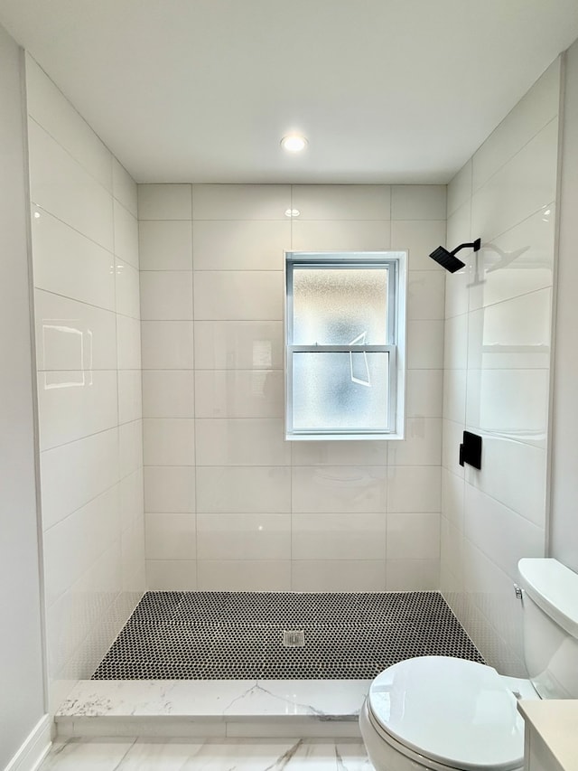 bathroom with toilet and a tile shower