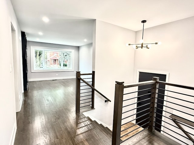 staircase featuring a chandelier and wood-type flooring