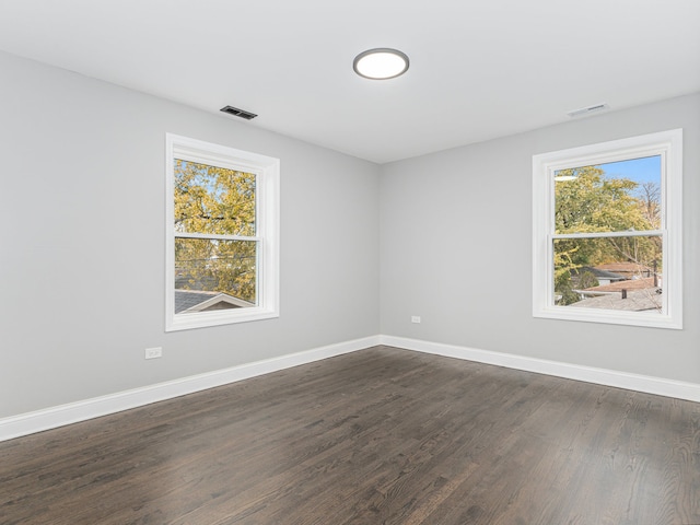 unfurnished room featuring plenty of natural light and dark hardwood / wood-style flooring