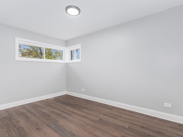 unfurnished room with dark hardwood / wood-style flooring