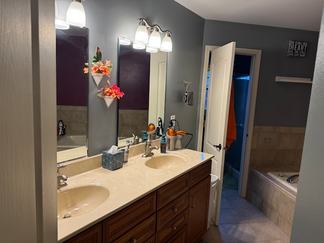 bathroom featuring vanity, tile patterned floors, and a relaxing tiled tub