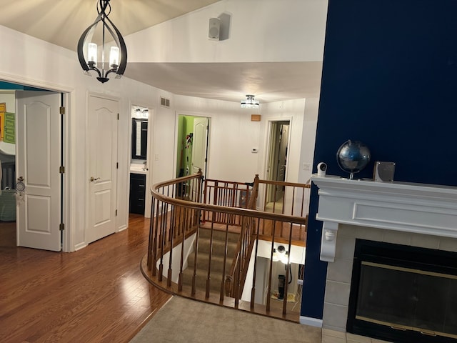 hall featuring hardwood / wood-style floors and an inviting chandelier