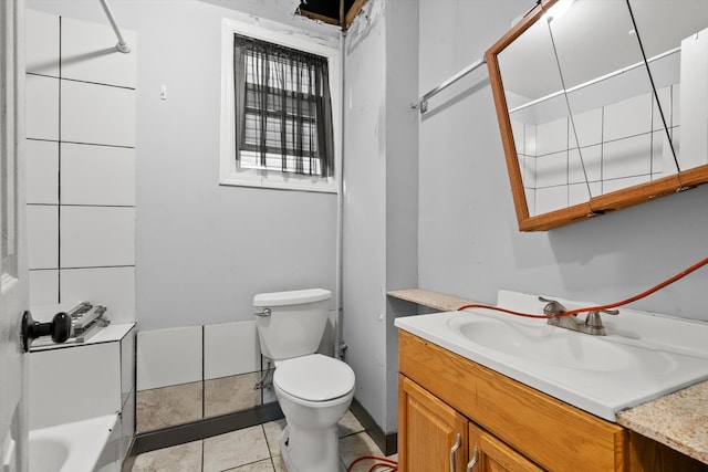 bathroom with toilet, a tub, vanity, and tile patterned floors