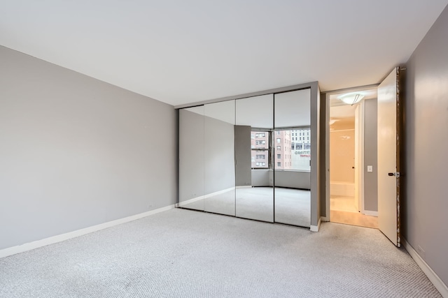 unfurnished bedroom with light carpet and a closet