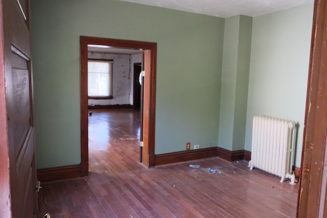 spare room with radiator and dark hardwood / wood-style floors