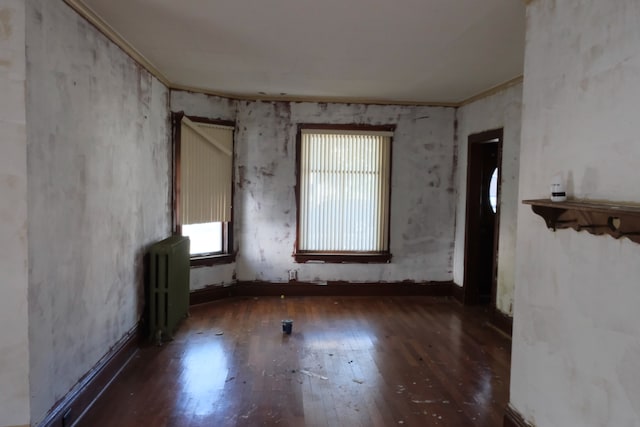 spare room with ornamental molding, radiator heating unit, and dark hardwood / wood-style floors