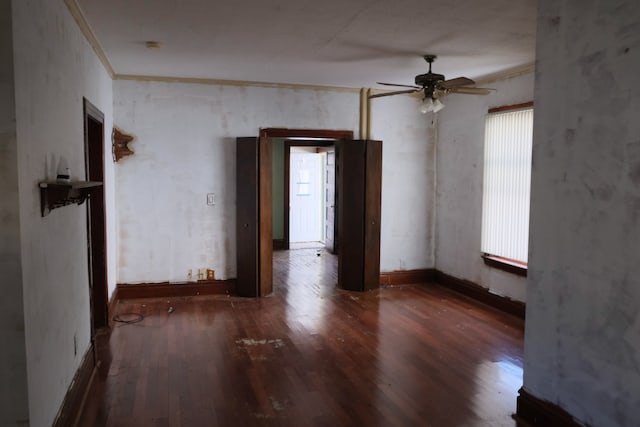 empty room with ceiling fan, dark hardwood / wood-style floors, and crown molding