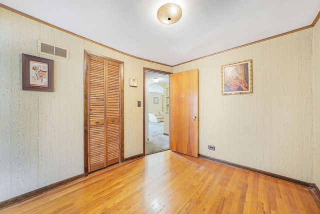 spare room with hardwood / wood-style floors and crown molding