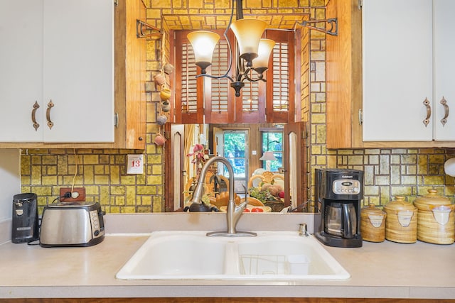 kitchen featuring white cabinets, decorative backsplash, sink, and white appliances