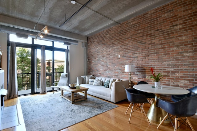 living room with hardwood / wood-style floors and brick wall