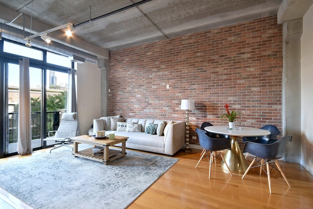 living room featuring hardwood / wood-style floors and brick wall