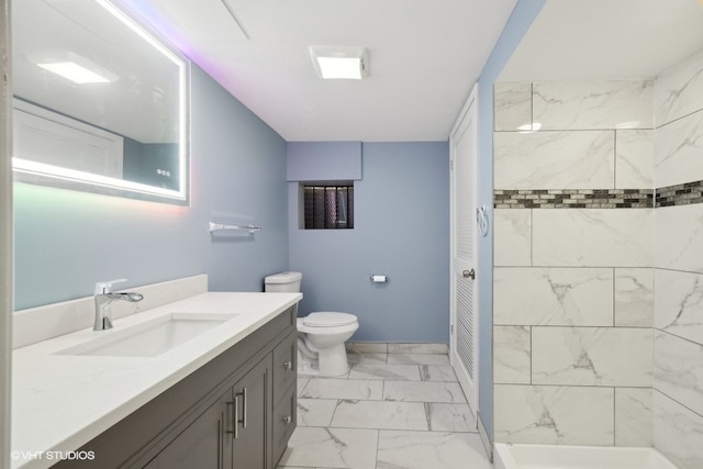 bathroom with toilet, vanity, and a tile shower