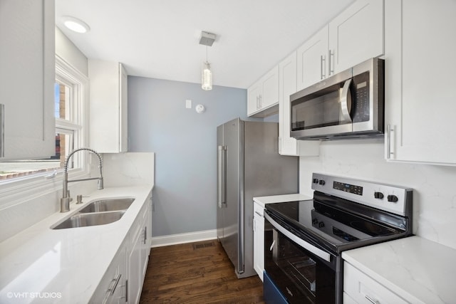 kitchen with stainless steel appliances, white cabinetry, dark hardwood / wood-style floors, pendant lighting, and sink