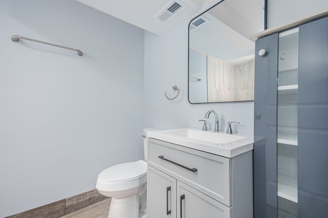 bathroom with vanity, hardwood / wood-style flooring, and toilet