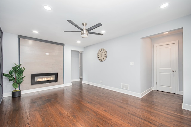 unfurnished living room featuring ceiling fan, dark hardwood / wood-style floors, and a fireplace