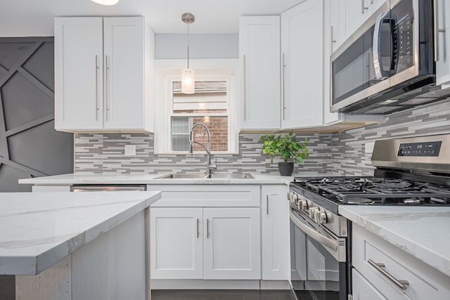 kitchen with decorative backsplash, white cabinetry, appliances with stainless steel finishes, and sink