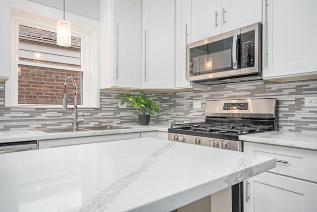 kitchen featuring white cabinetry, decorative backsplash, stainless steel appliances, and sink