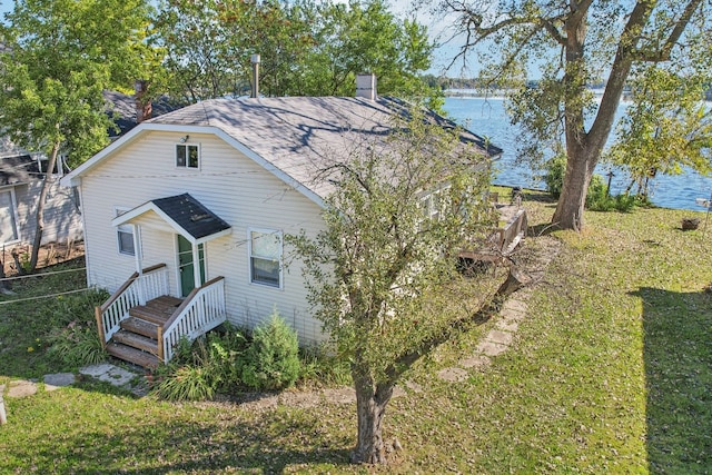 view of front of home with a front yard and a water view