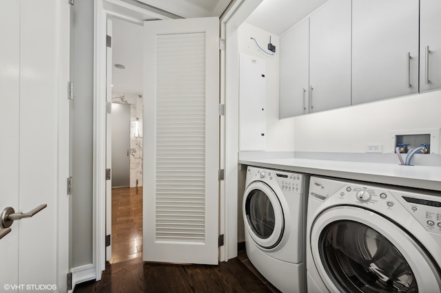 laundry area featuring washer and clothes dryer, dark hardwood / wood-style flooring, and cabinets