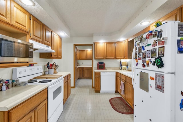 kitchen featuring a textured ceiling and white appliances