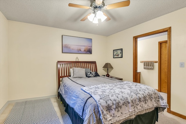 bedroom with a textured ceiling, light carpet, and ceiling fan