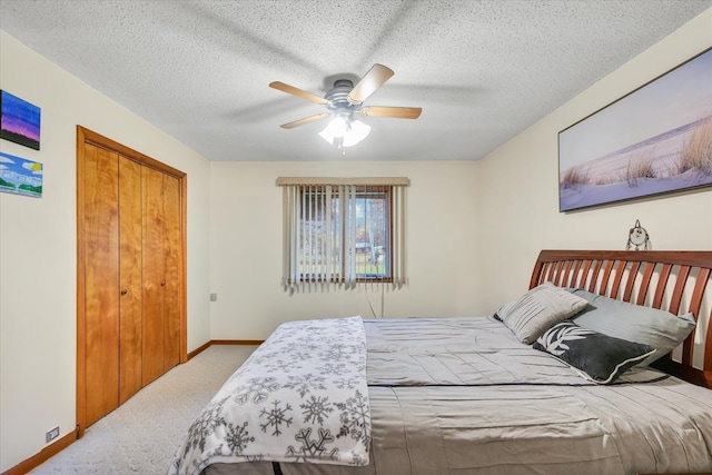 bedroom with a closet, a textured ceiling, light colored carpet, and ceiling fan