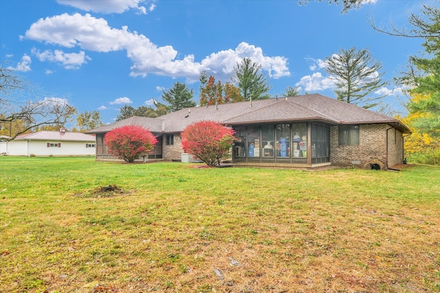 back of house featuring a sunroom and a yard