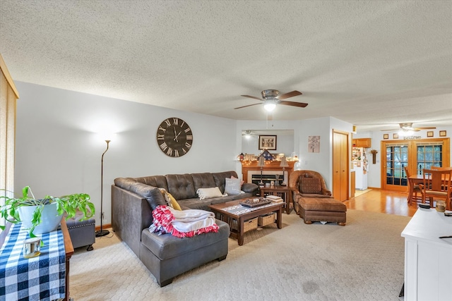 living room featuring ceiling fan, a textured ceiling, french doors, and light colored carpet