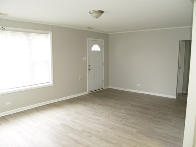 foyer with ornamental molding and hardwood / wood-style floors