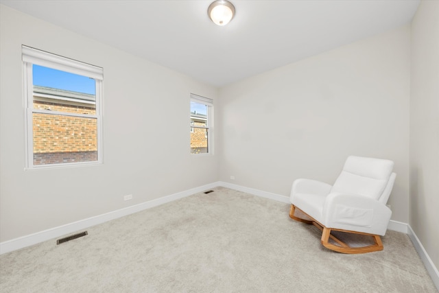 living area featuring light carpet