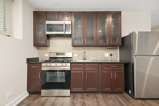 kitchen with stainless steel appliances, wood-type flooring, and sink