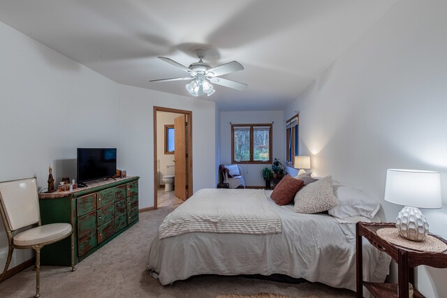 carpeted bedroom with ceiling fan and ensuite bath