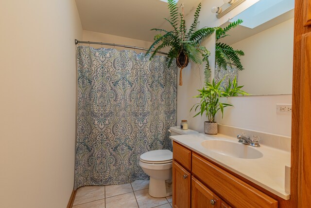 bathroom featuring toilet, vanity, a skylight, and tile patterned floors